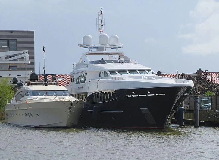 a large white boat sits next to a smaller boat aboard BAGHEERA Yacht for Charter