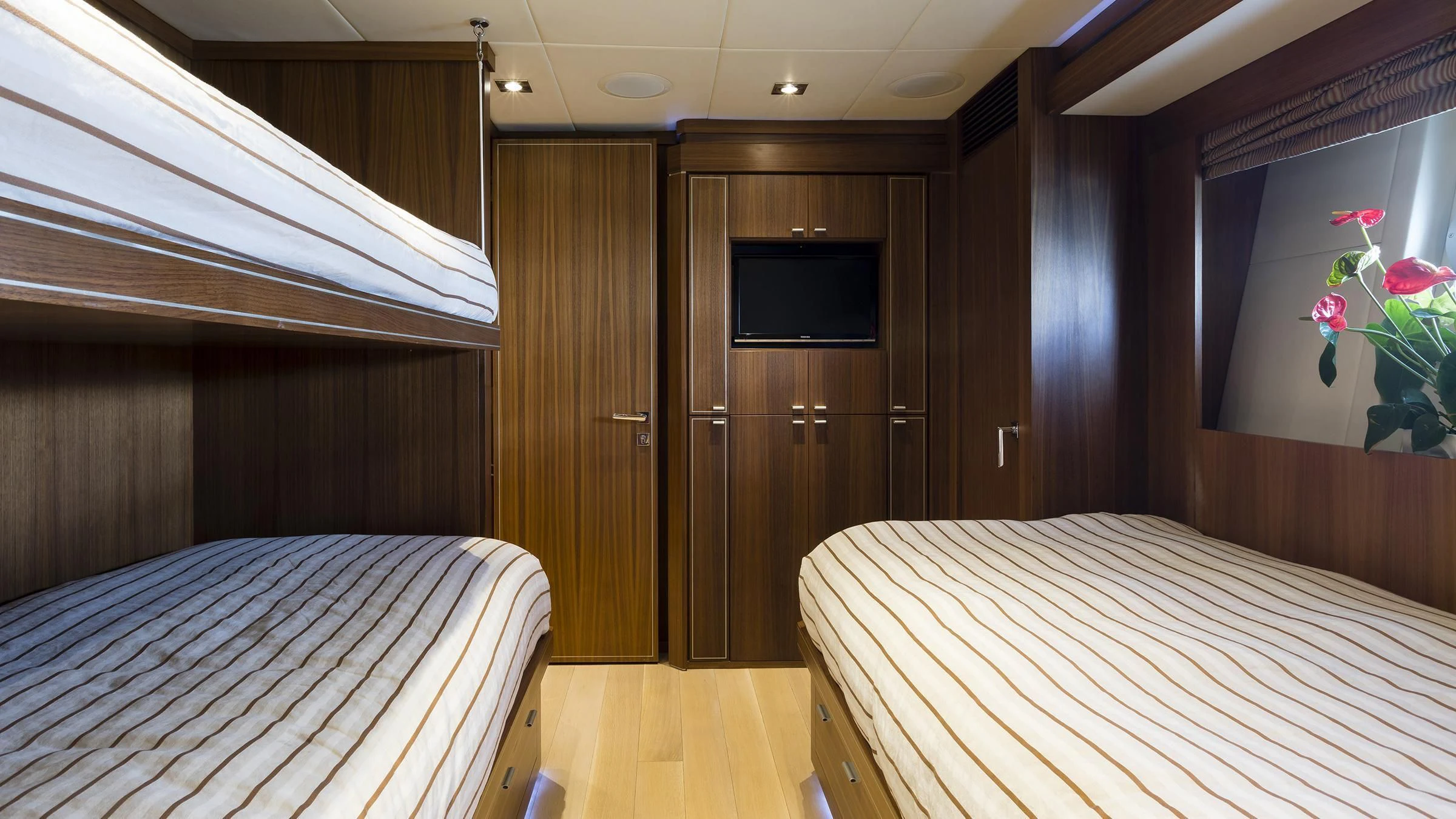 a room with a bed and a television aboard BAGHEERA Yacht for Charter