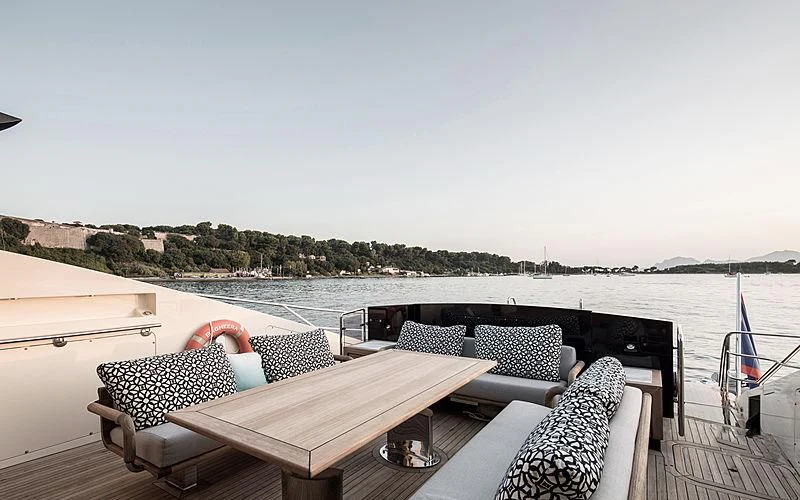 a deck with chairs and a table on it aboard BAGHEERA Yacht for Charter