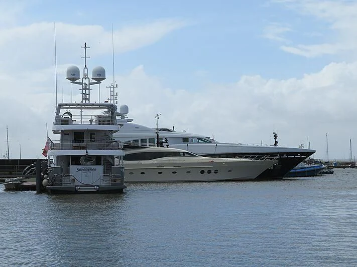 a couple of large boats sit in a harbor aboard BAGHEERA Yacht for Charter