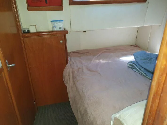 a bed with a blue blanket aboard PHANTOM EXPLORER Yacht for Sale