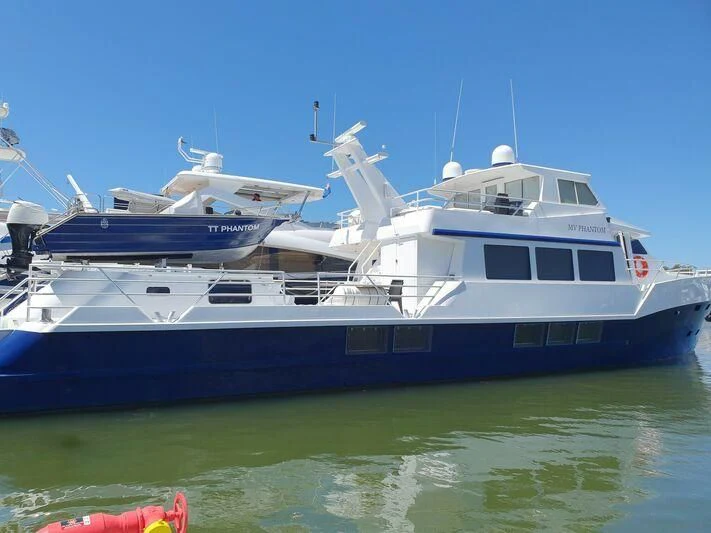 a large boat in the water aboard PHANTOM EXPLORER Yacht for Sale