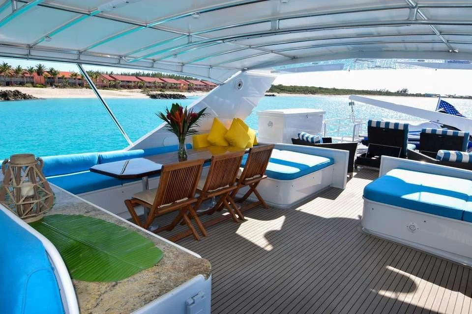 a deck with a table and chairs on it aboard ISLAND VIBE Yacht for Sale