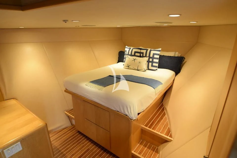 a bed with a blue and white pillow on it aboard ISLAND VIBE Yacht for Sale