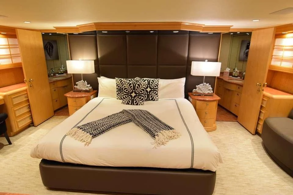 a bed with a white comforter aboard ISLAND VIBE Yacht for Sale