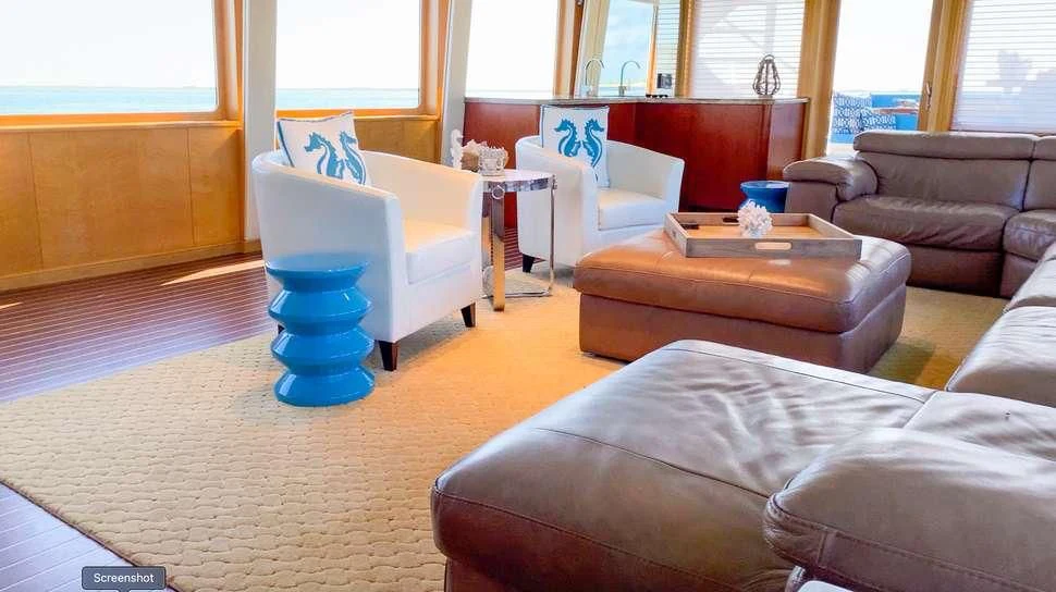 a living room with a blue chair and a blue table aboard ISLAND VIBE Yacht for Sale