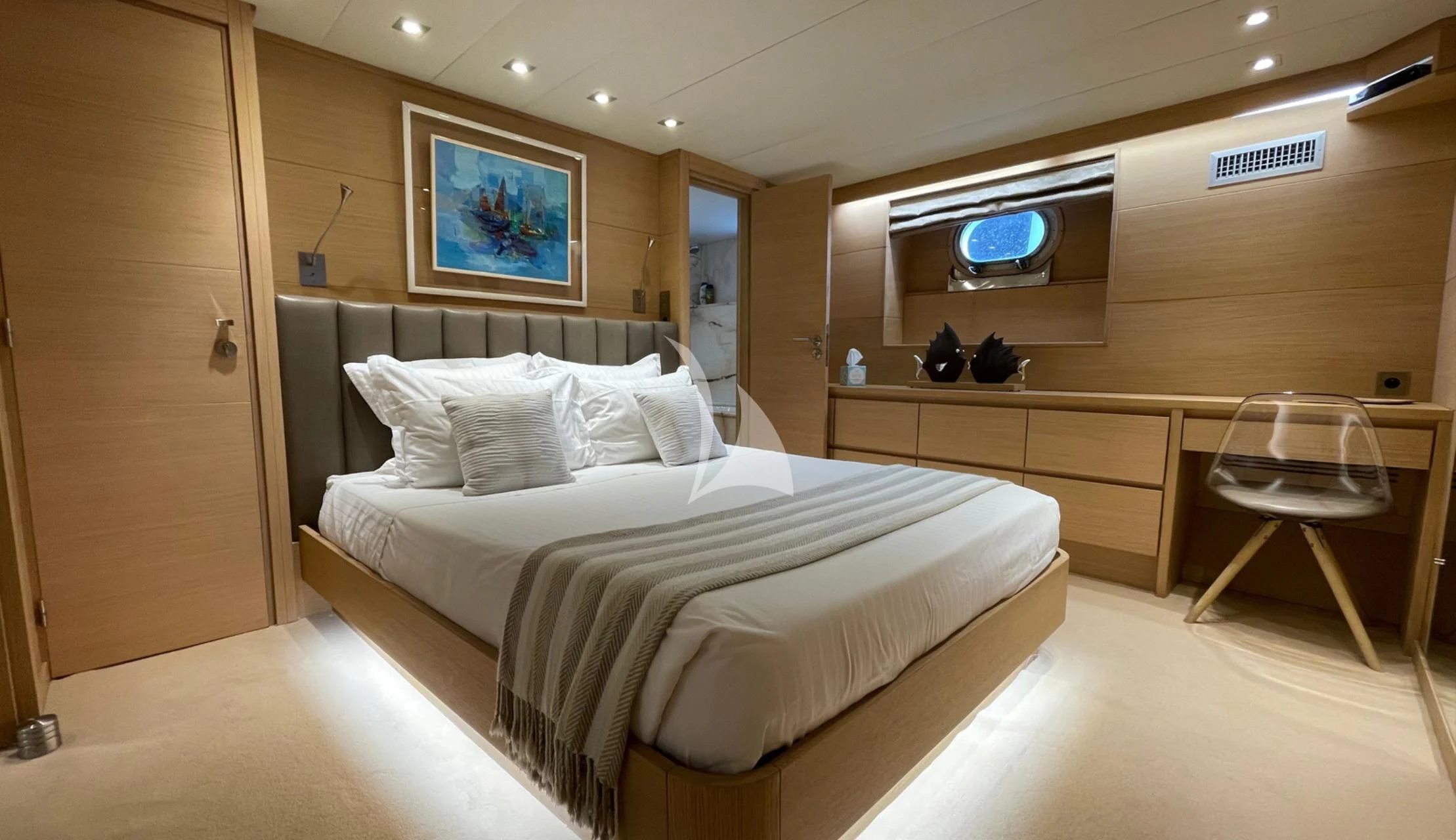 a room with a bed and desk aboard LADY JERSEY Yacht for Charter