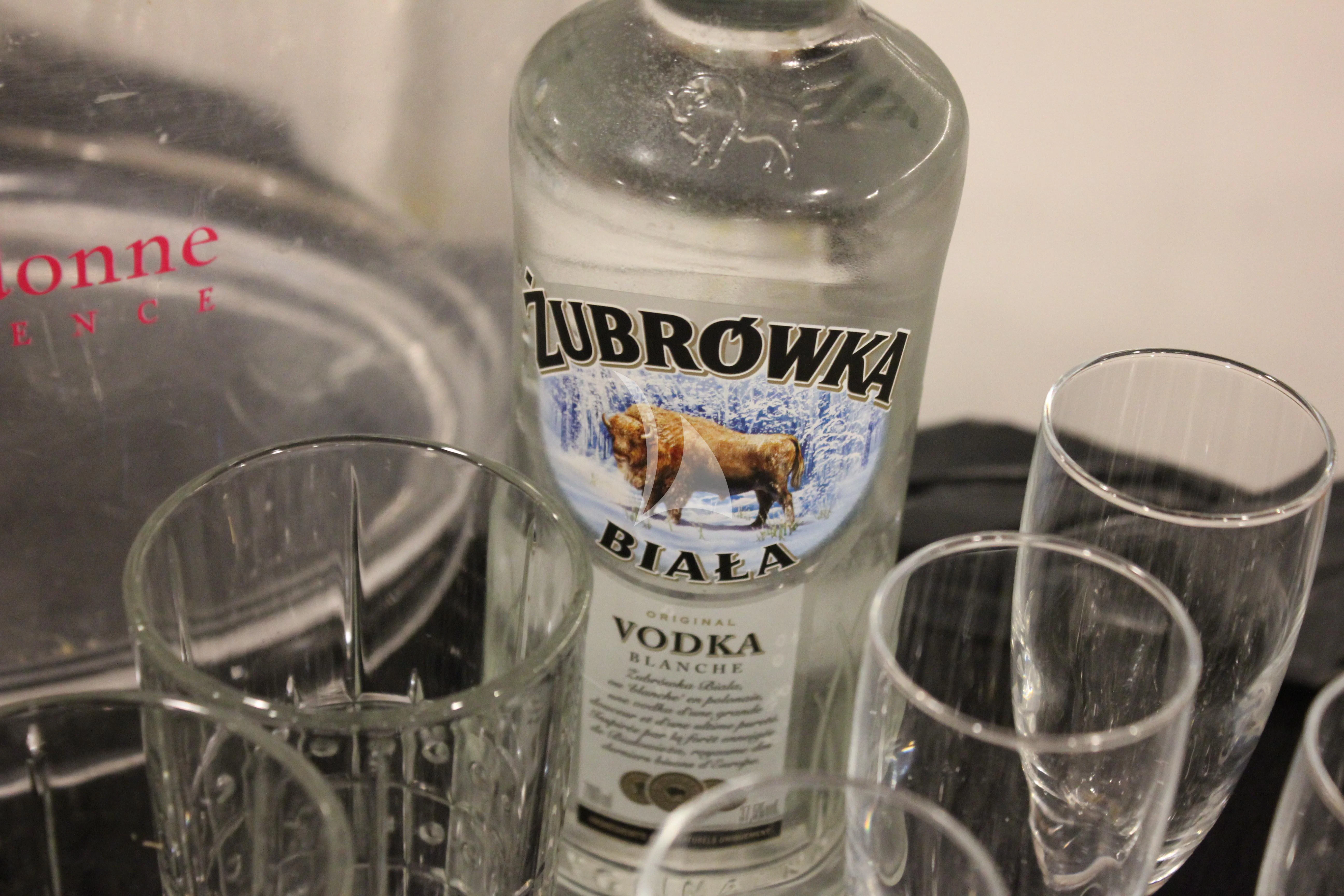 a bottle of alcohol next to a glass of water aboard LADY JERSEY Yacht for Charter