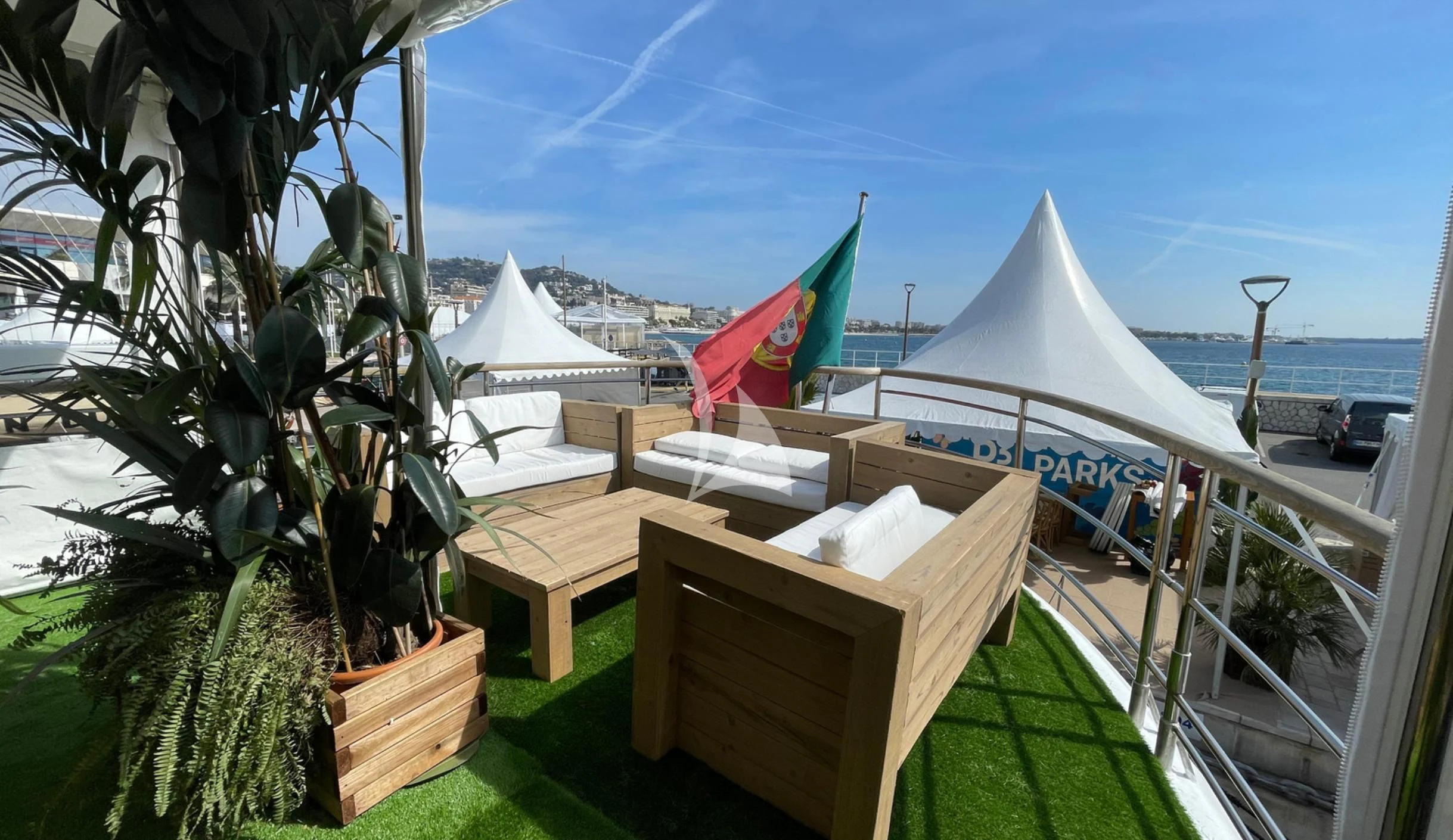 a group of tents and a picnic table on a patio with a body of water in the background aboard LADY JERSEY Yacht for Charter