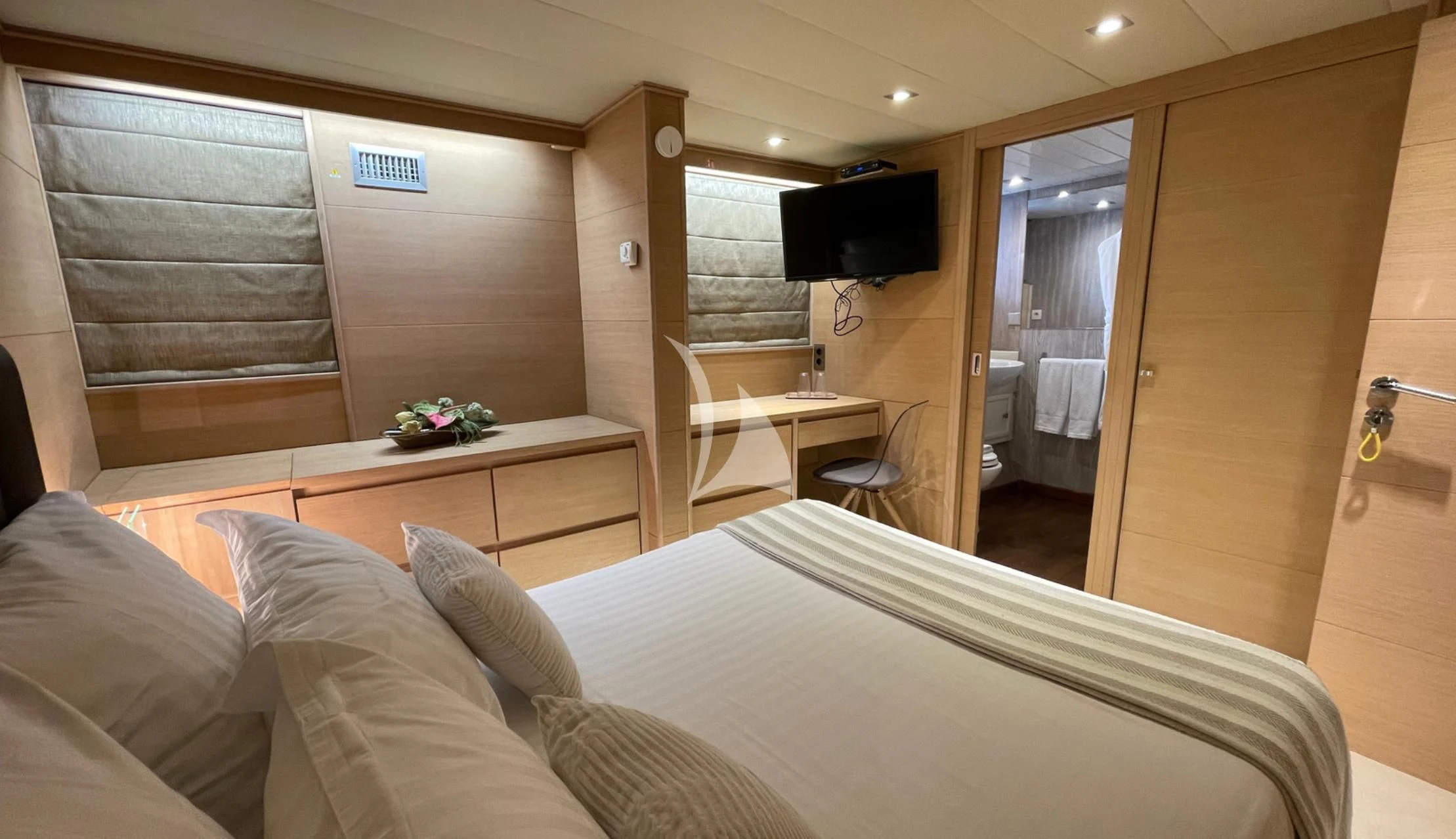 a room with a bed and a television aboard LADY JERSEY Yacht for Charter