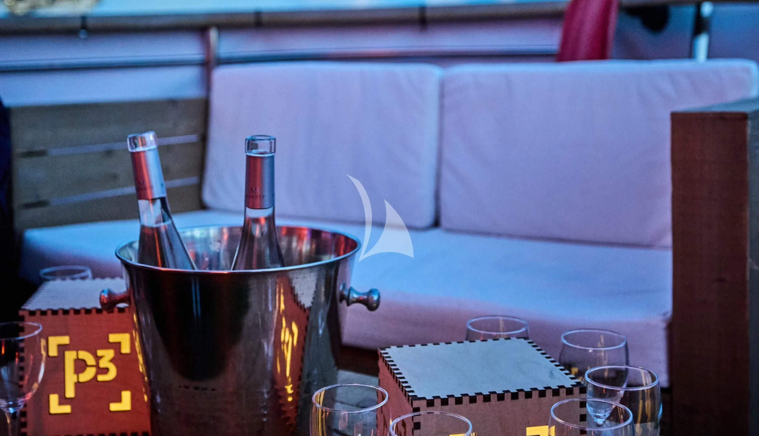 a glass of liquid and a bottle on a table aboard LADY JERSEY Yacht for Charter