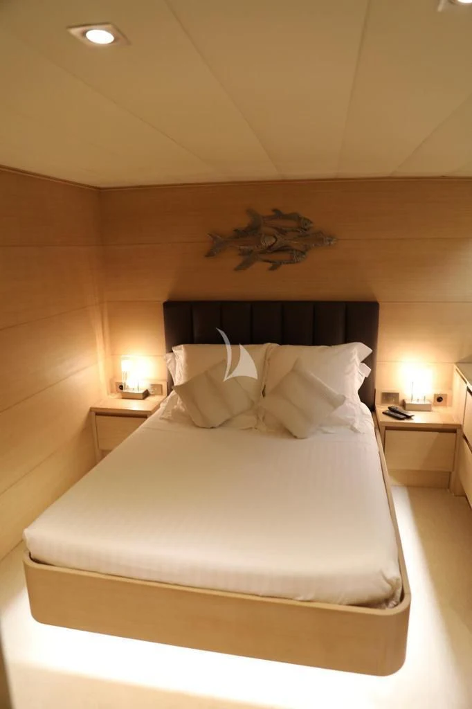 a bed with a white comforter aboard LADY JERSEY Yacht for Charter