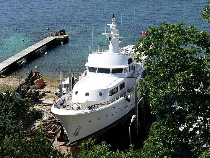 a white boat docked at a pier aboard LADY JERSEY Yacht for Charter