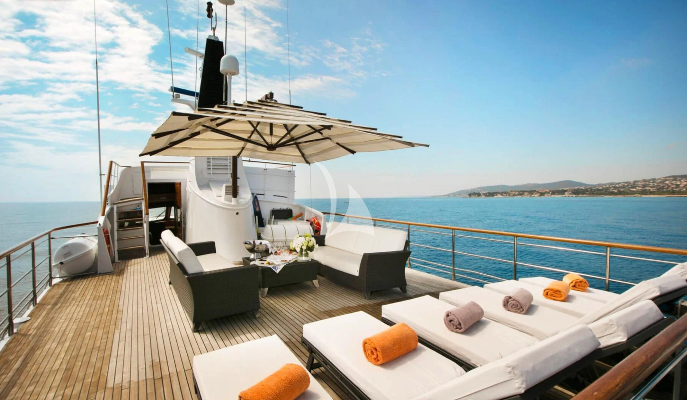 a deck with a large ship in the background aboard LADY JERSEY Yacht for Charter
