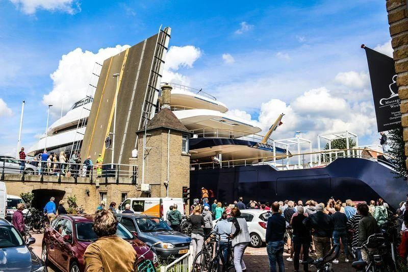 a group of people standing outside a building with cars and a helicopter aboard LONIAN Yacht for Sale