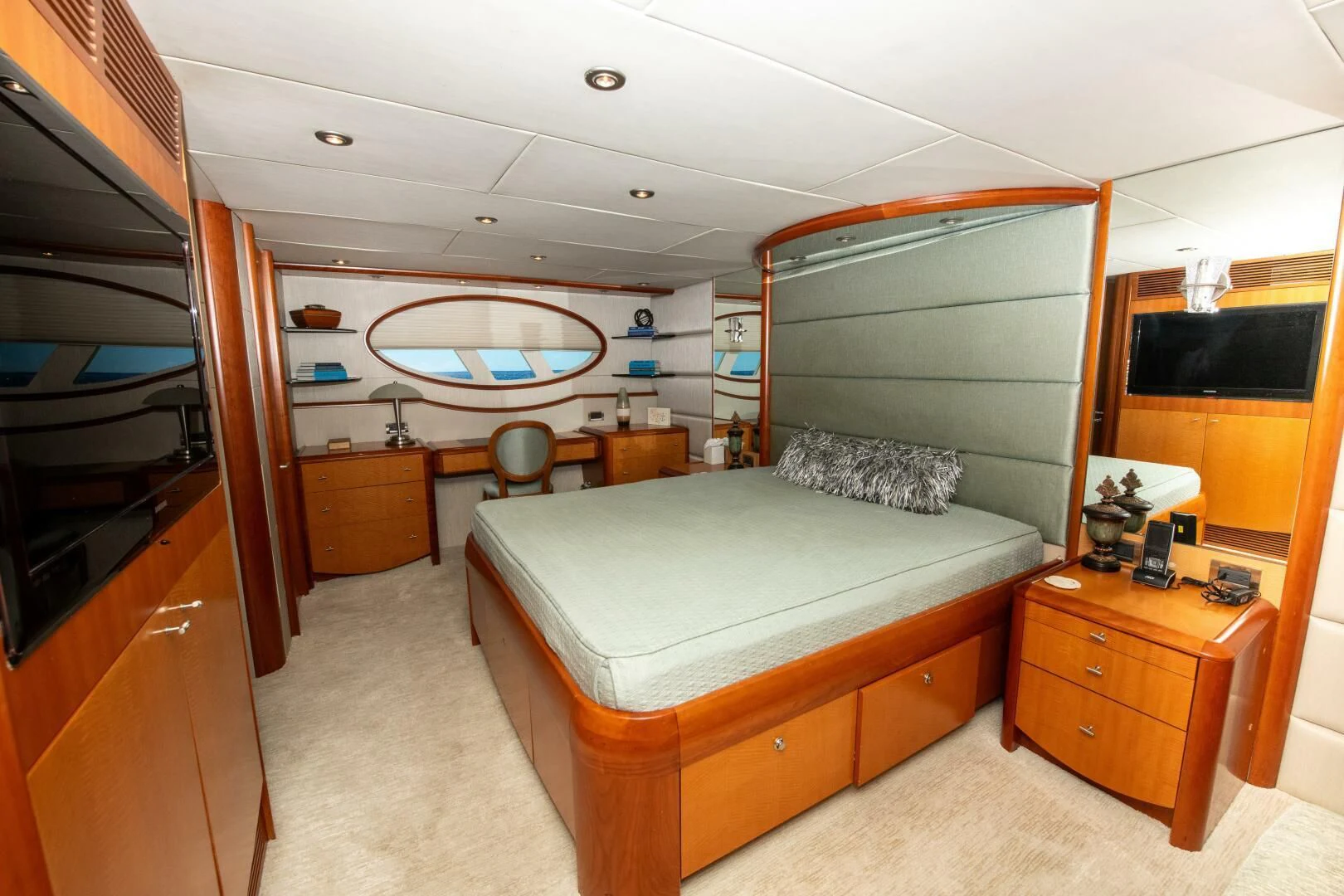 a bedroom with a bed and a dresser aboard STARFIRE Yacht for Sale