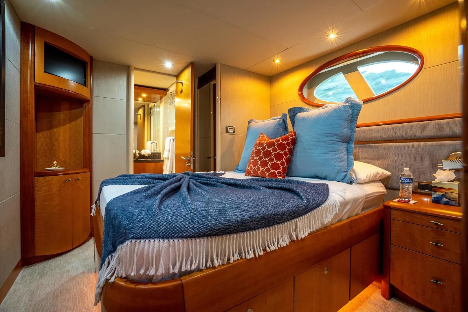 a bed with blue sheets aboard STARFIRE Yacht for Sale