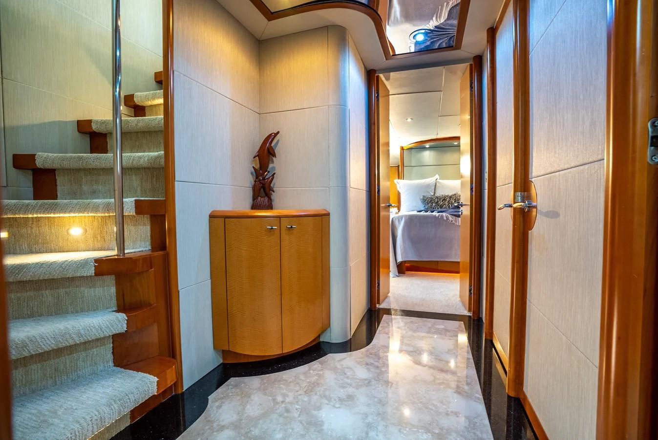 a room with a wood cabinet and a staircase aboard STARFIRE Yacht for Sale