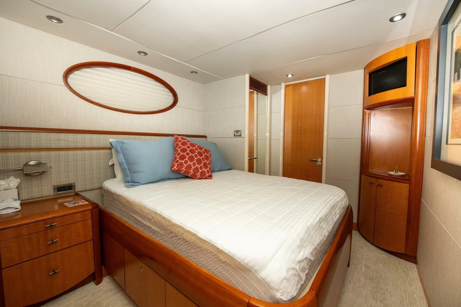 a bedroom with a bed and a dresser aboard STARFIRE Yacht for Sale