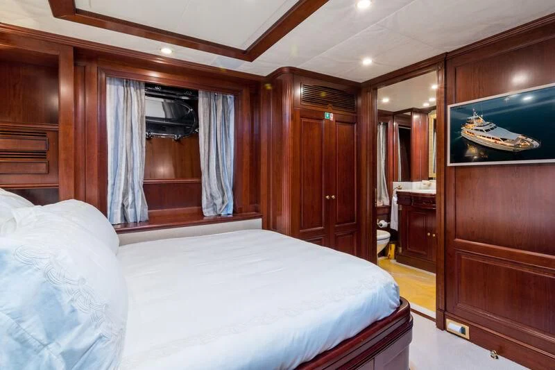 a bedroom with a bed and a dresser aboard ENDLESS SUMMER Yacht for Sale