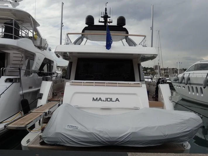 a white boat with a blue stripe aboard SEN Yacht for Sale