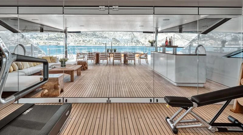 a room with a large deck and chairs and a large window aboard ZAZOU Yacht for Sale