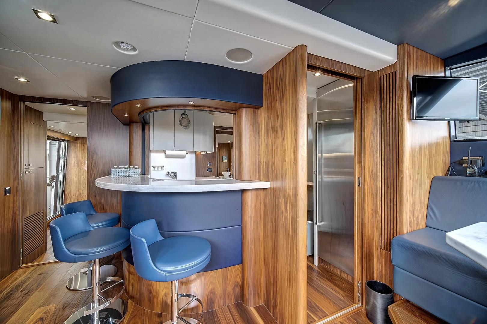 a room with a wood floor and a blue chair and a wood door aboard 'S NOON SOMEWHERE Yacht for Sale