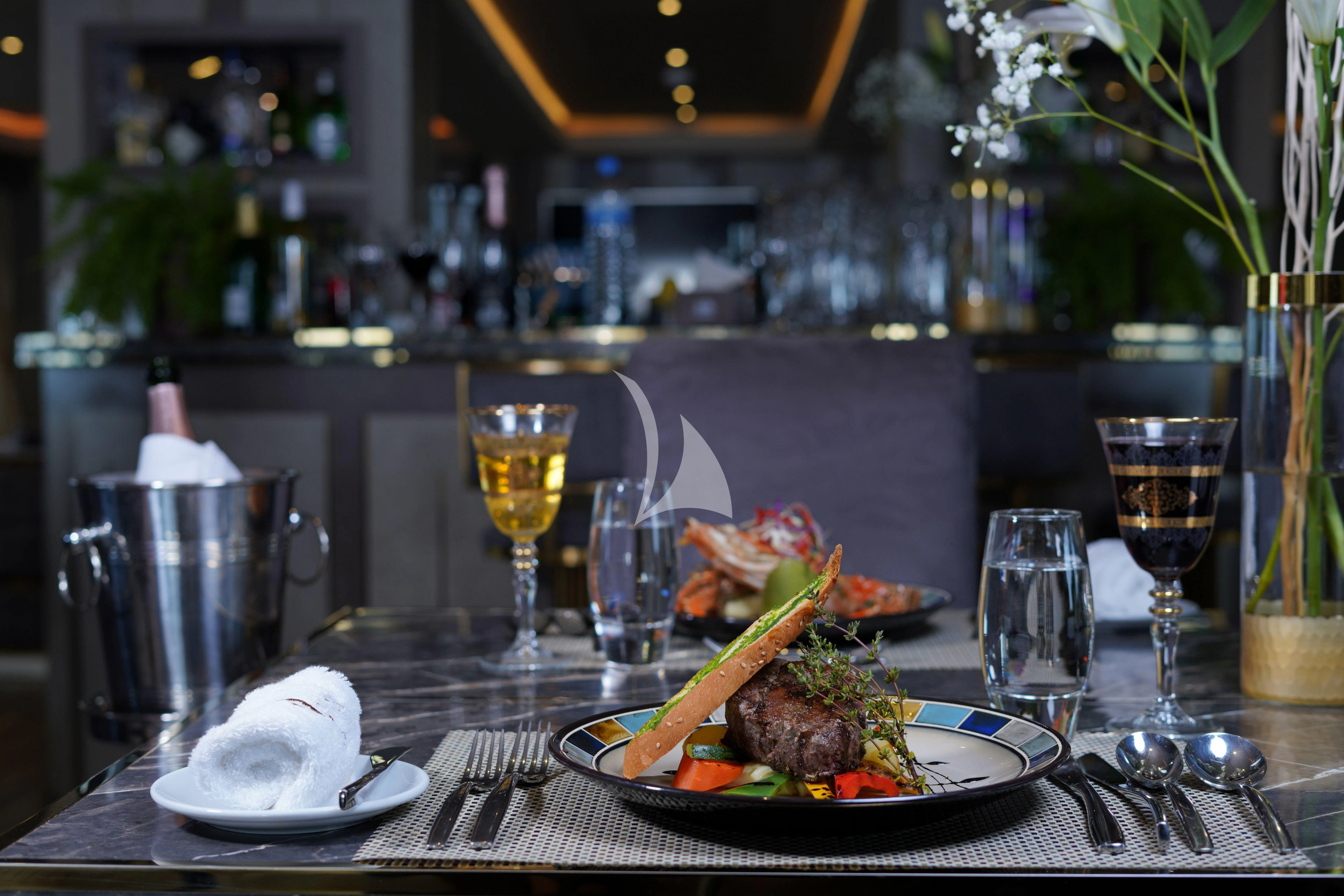 a table with food and wine aboard ARK NOBLE Yacht for Sale