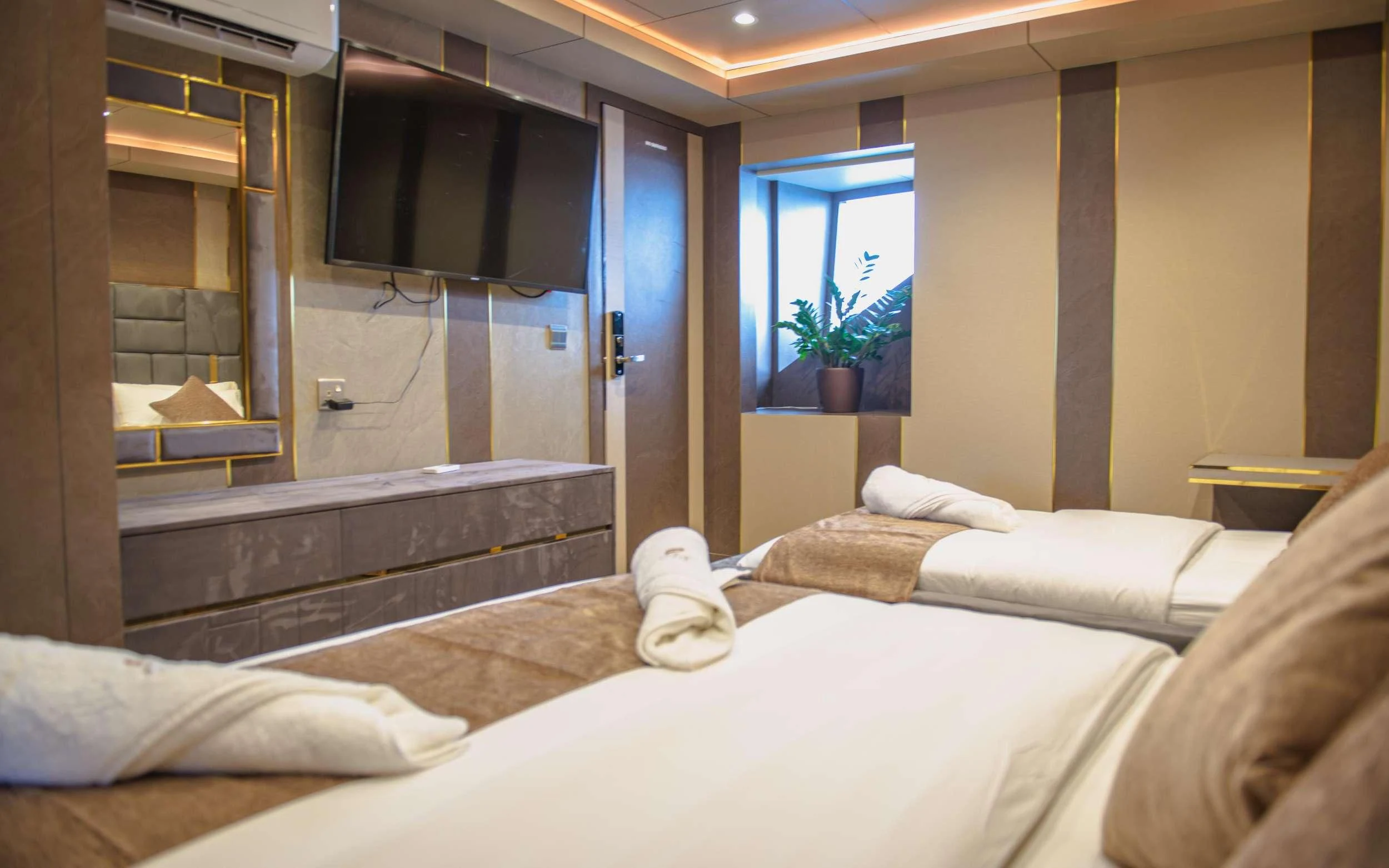 a room with a bed and a television aboard ARK NOBLE Yacht for Sale