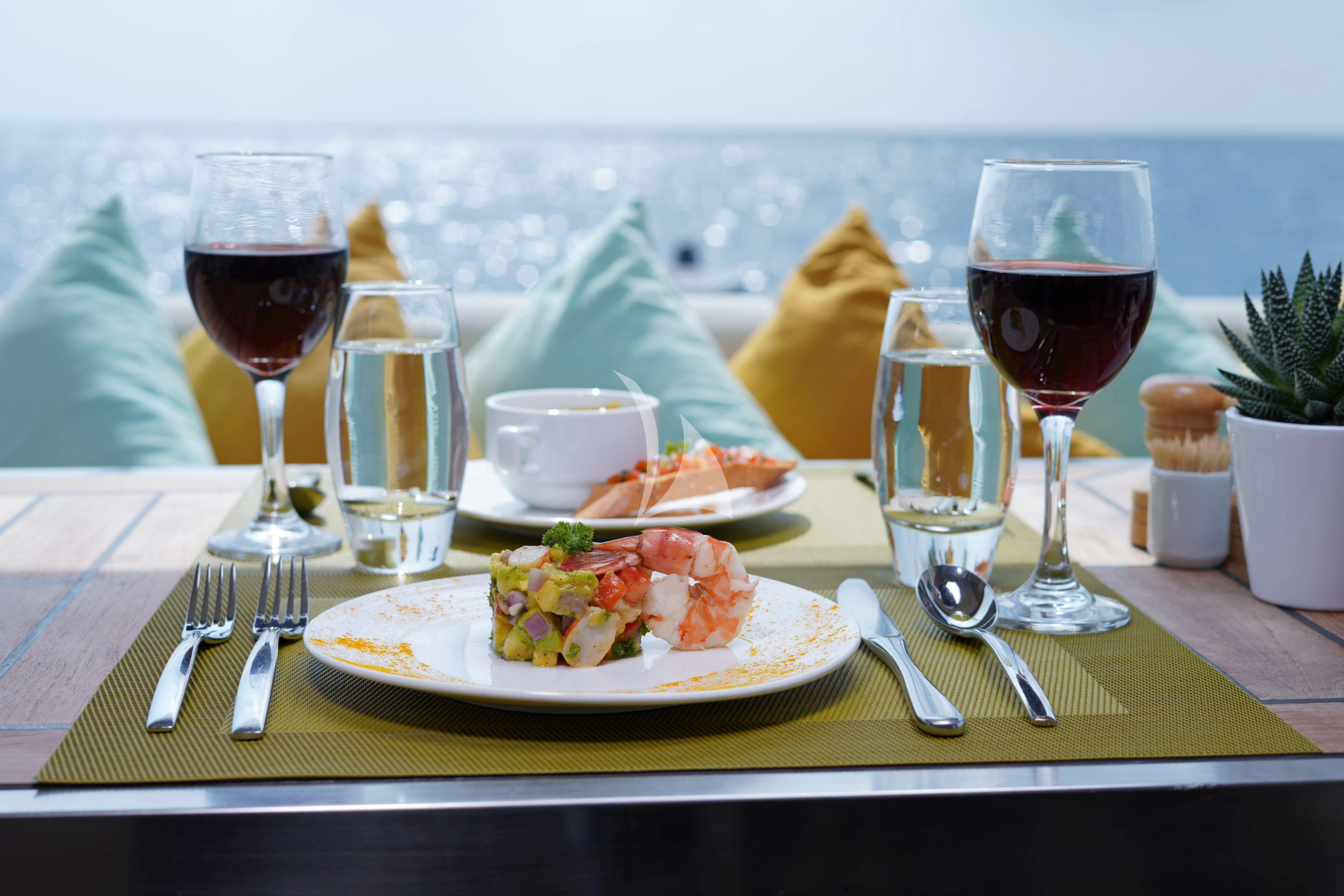 a table with food and wine aboard ARK NOBLE Yacht for Sale