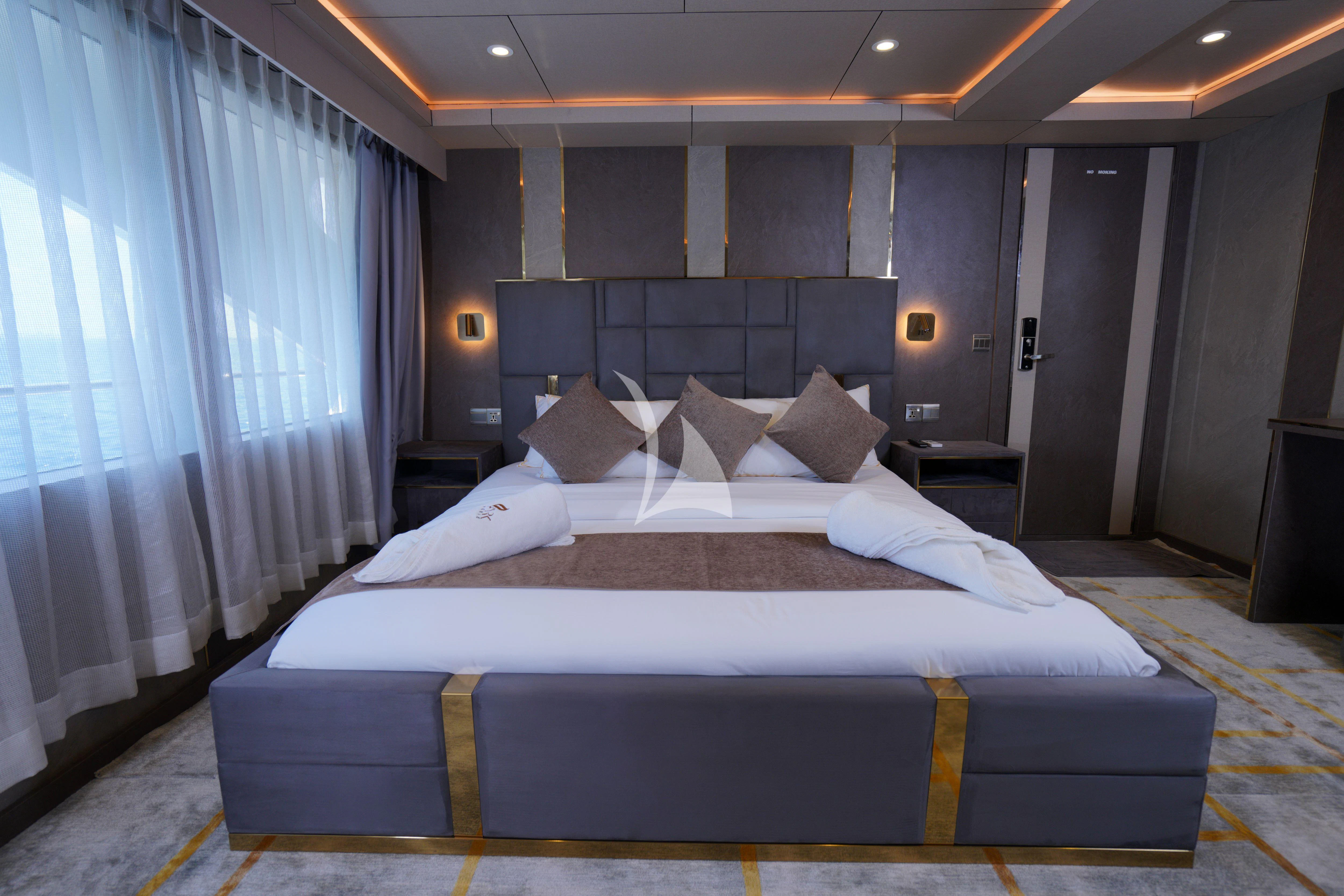 a bed with blue and white sheets aboard ARK NOBLE Yacht for Sale