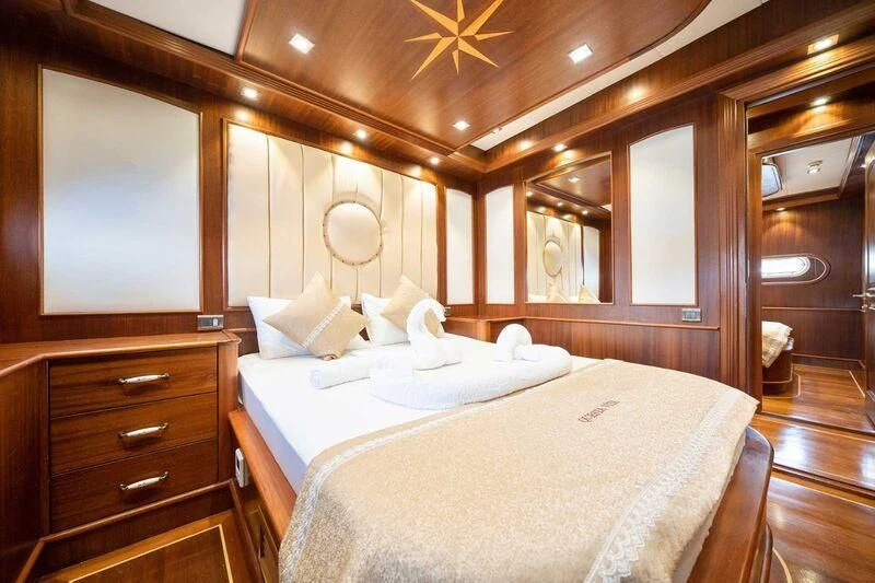 a bedroom with a bed and a mirror aboard QUESTA VITA Yacht for Sale