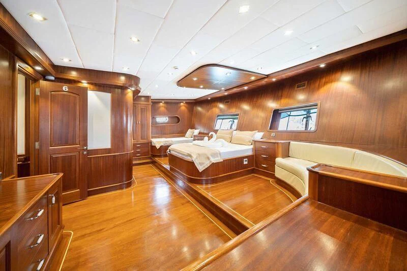 a room with a bed and a desk aboard QUESTA VITA Yacht for Sale