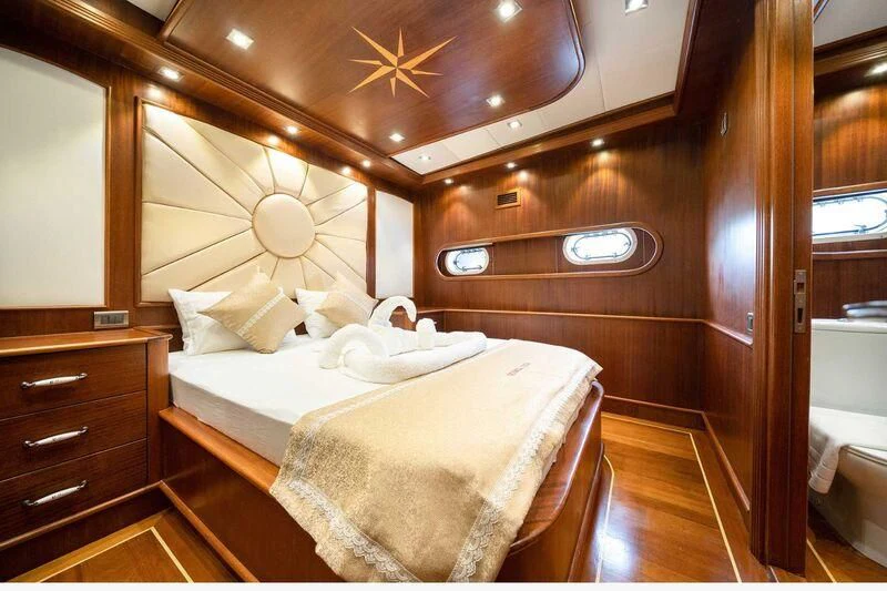 a room with a bed and a fan aboard QUESTA VITA Yacht for Sale