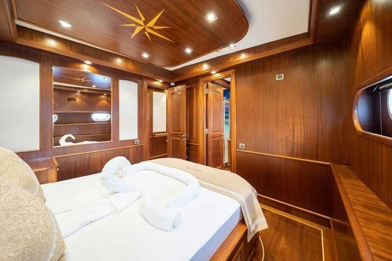 a room with a bed and a television aboard QUESTA VITA Yacht for Sale