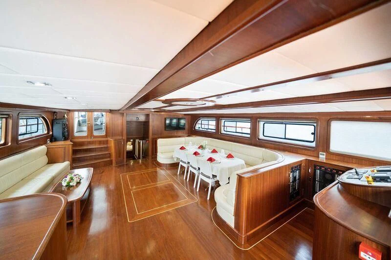 a room with a bed and a table aboard QUESTA VITA Yacht for Sale