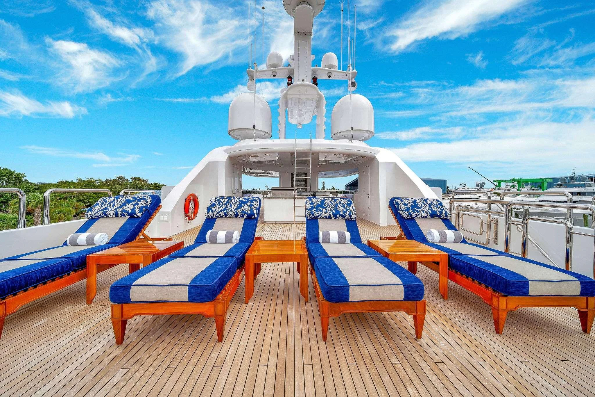 a deck with chairs and a boat on it aboard VALHALLA Yacht for Sale