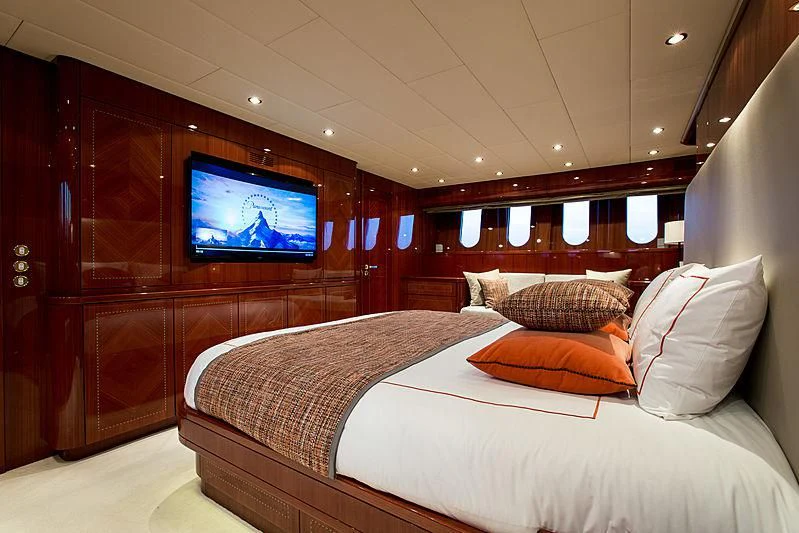 a bed with a television on the wall aboard KIDI ONE Yacht for Sale