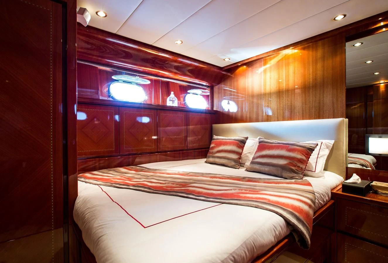 a bed with a white and red comforter and pillows aboard KIDI ONE Yacht for Sale