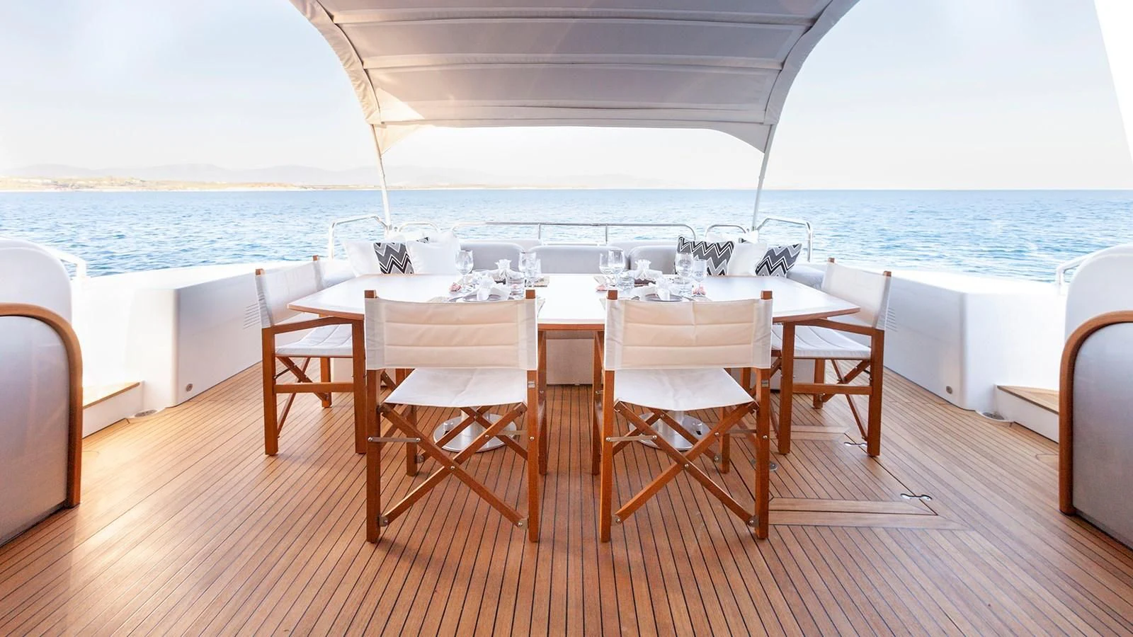 a table and chairs on a deck overlooking the ocean aboard KIDI ONE Yacht for Sale
