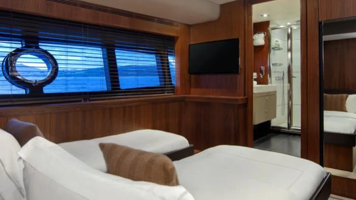 a room with a bed and a tv on the wall aboard BRAVA Yacht for Sale