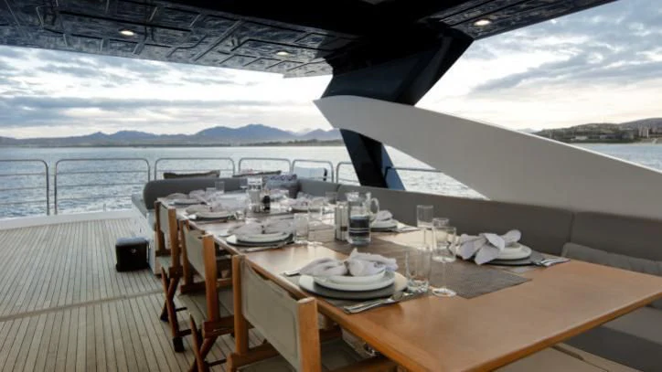 a table set for a dinner on a deck aboard BRAVA Yacht for Sale