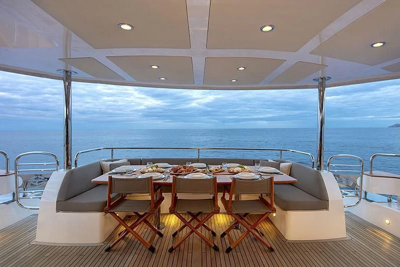 a table set for a meal on a deck overlooking the ocean aboard BRAVA Yacht for Sale