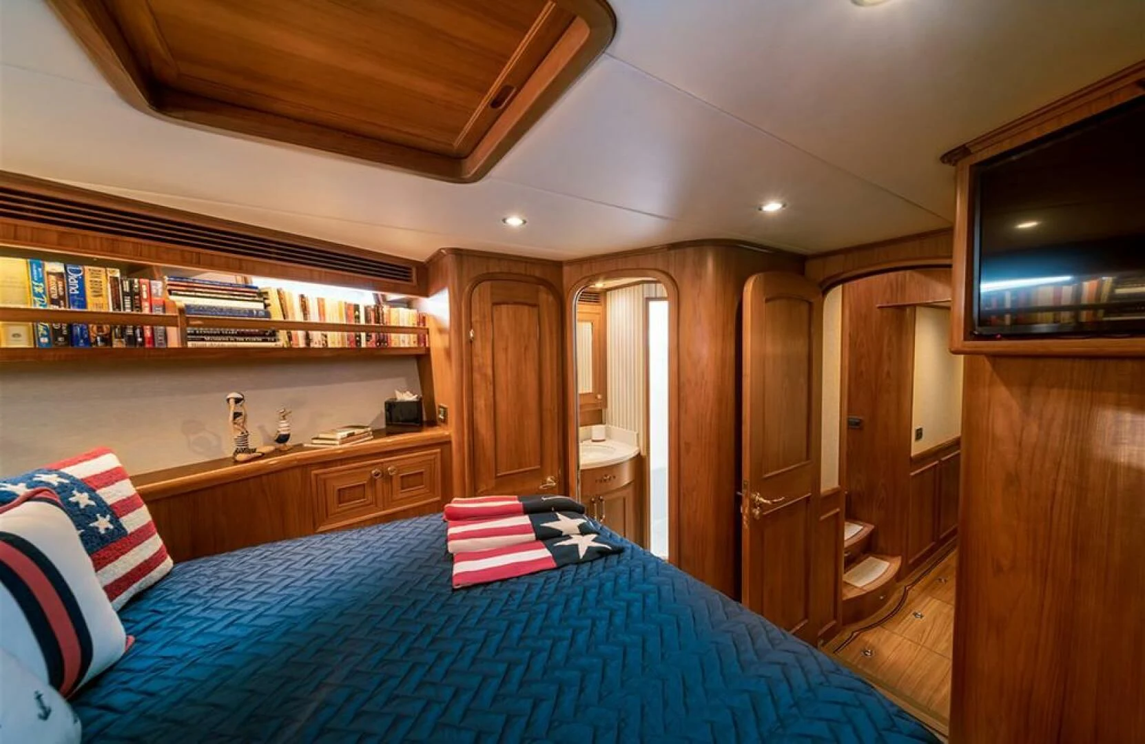 a bedroom with a blue bed spread aboard JULIANNE Yacht for Sale