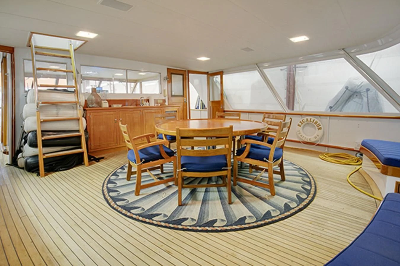 a room with a table chairs and a ladder aboard EXCALIBUR Yacht for Sale