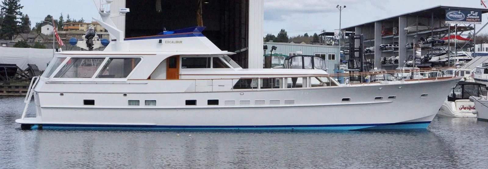 a white yacht in a harbor aboard EXCALIBUR Yacht for Sale