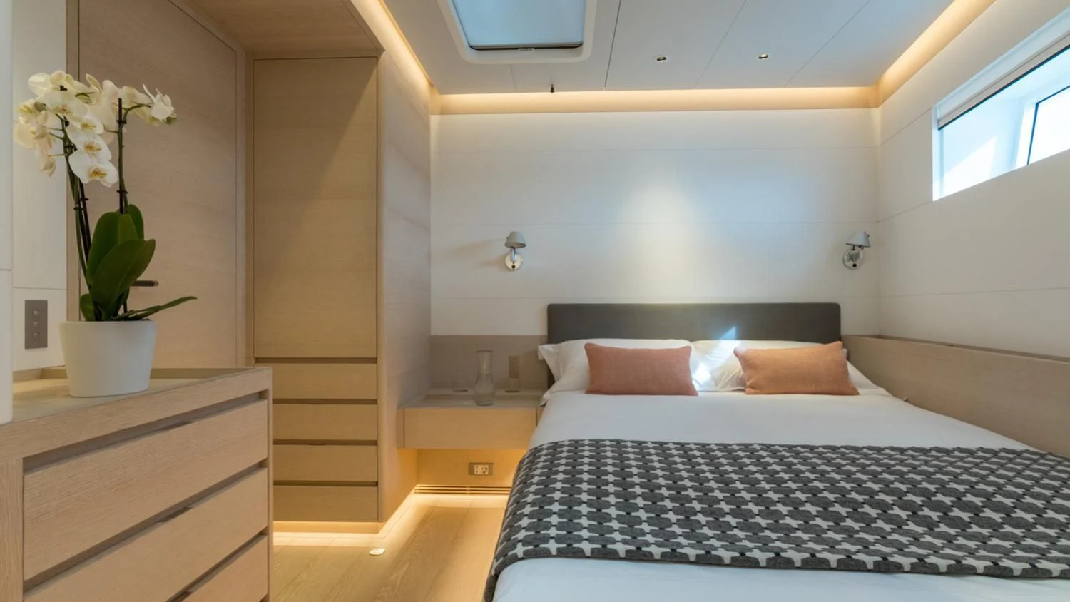 a bed with a flower pot on the side aboard CERVO Yacht for Sale