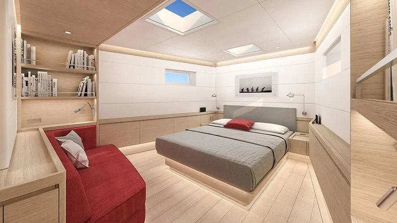 a bedroom with a bed and a red couch aboard CERVO Yacht for Sale