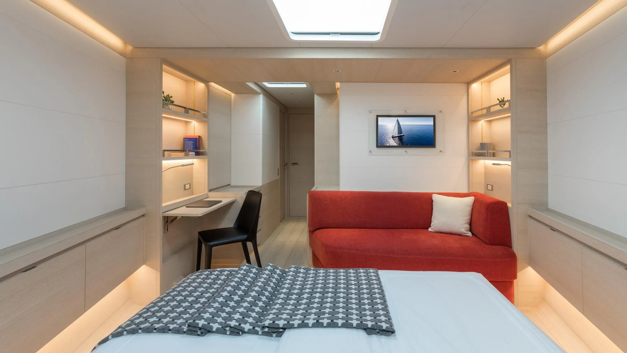 a room with a red couch and a blue table with a white table aboard CERVO Yacht for Sale