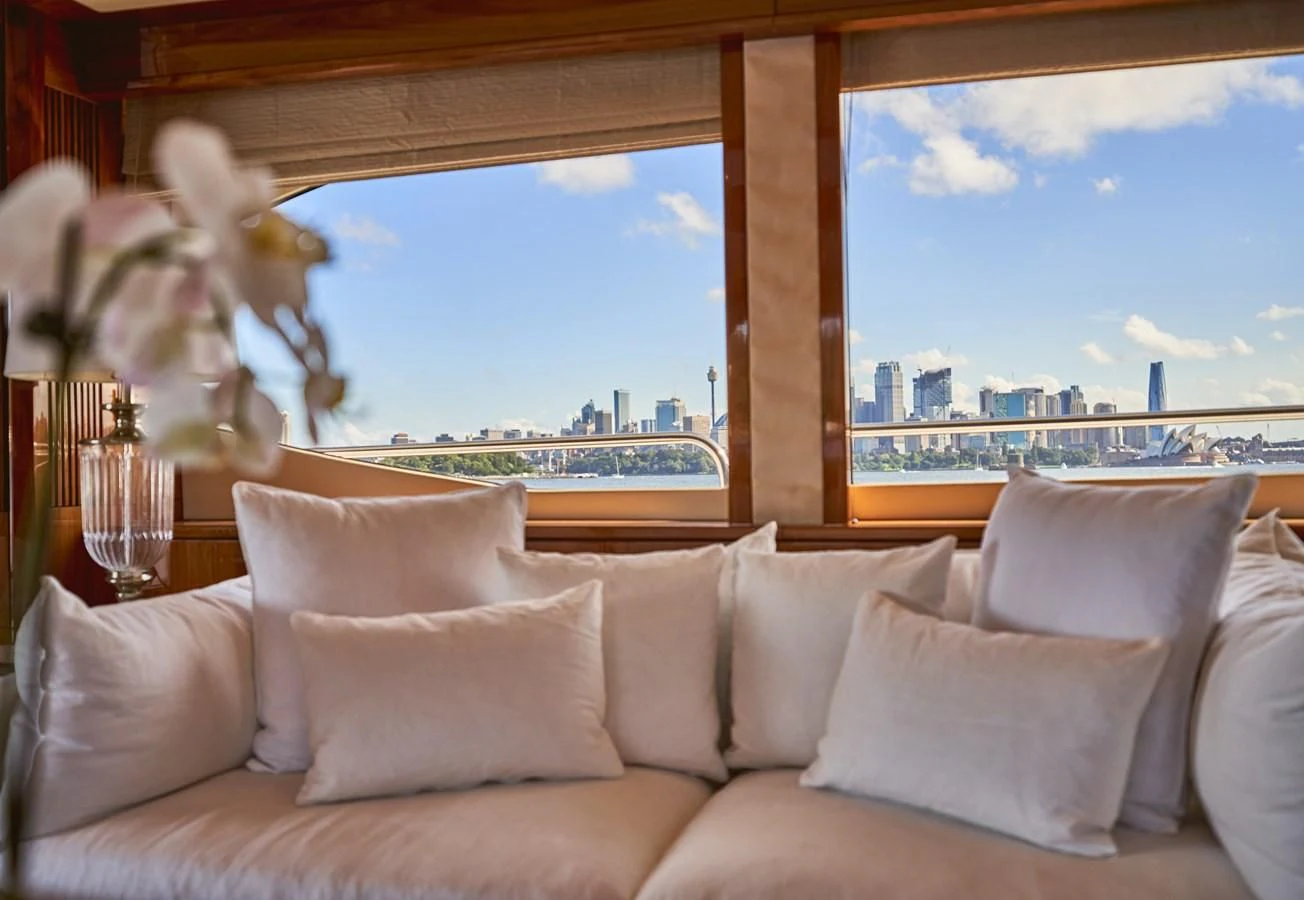 a couch with pillows and a window aboard CHAOS Yacht for Sale